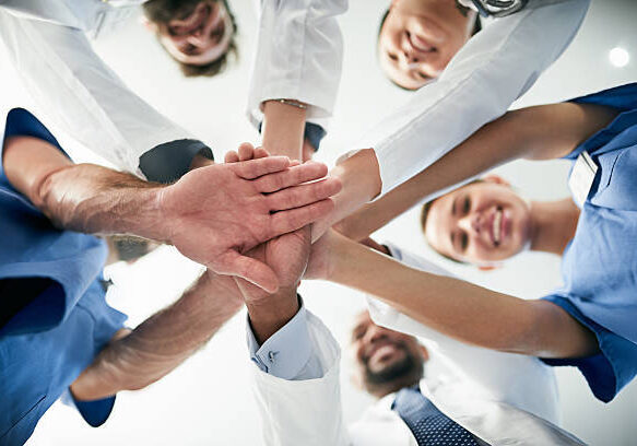 Shot of a diverse team of doctors joining their hands together in unity Shot of a diverse team of doctors joining their hands together in unity